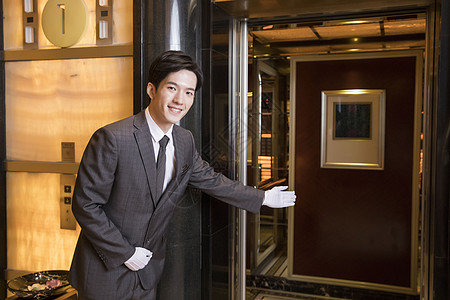 酒店服务员为顾客开电梯图片