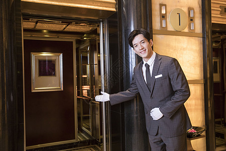 酒店服务员为顾客开电梯背景