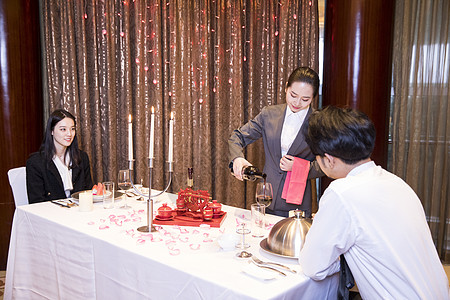 烛光晚餐,酒店服务人员给客户倒酒背景