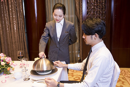 酒店服务员给顾客打开餐盖西餐高清图片素材