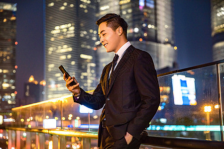 夜景人物年轻商务男子天桥玩手机背景