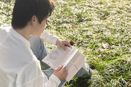 在草坪上看书的男生图片