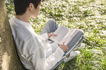 在草坪上看书的男生图片