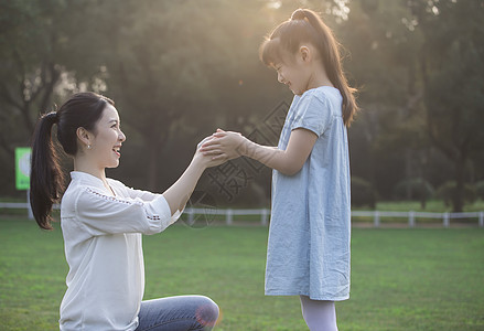 草坪玩耍女儿和妈妈草地上玩耍背景