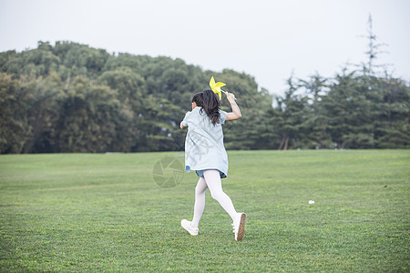 拿着风车奔跑的小女孩图片