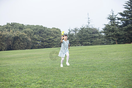 拿着风车奔跑的小女孩图片