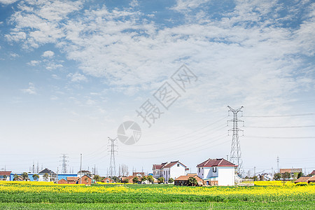 蓝天下的房屋农田和电网图片