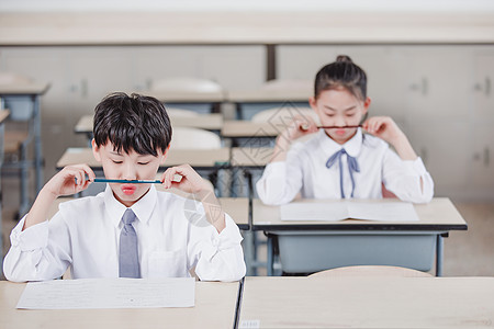 小学生手拿试卷小学生教室考试背景