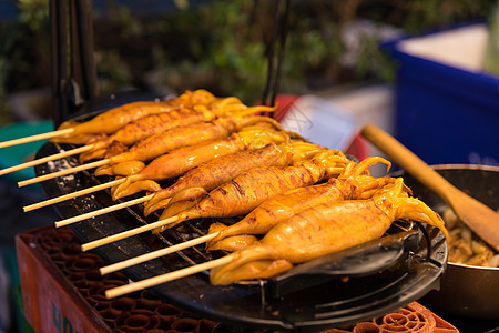 泰国夜市小吃烧烤烤鱿鱼背景图片