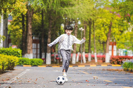 小学生放学踢足球背景图片