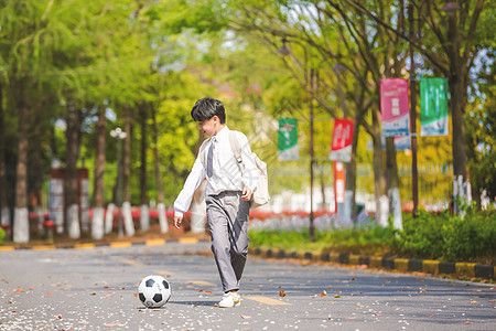小男孩放学踢足球图片