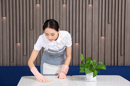 女性家政人员擦桌子背景图片