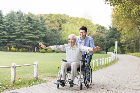 老年父子开心推轮椅图片