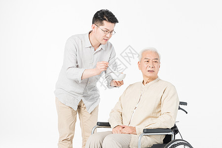 老年父子轮椅上喂食背景图片