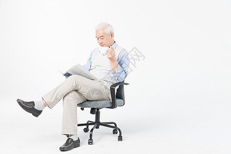 坐椅子的老人老年人看看书喝茶背景