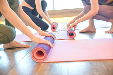 女性瑜伽锻炼整理瑜伽垫图片