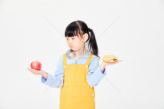 小女孩手拿汉堡和苹果图片