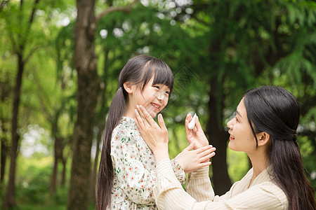 女儿和妈妈可爱母女擦防晒霜背景