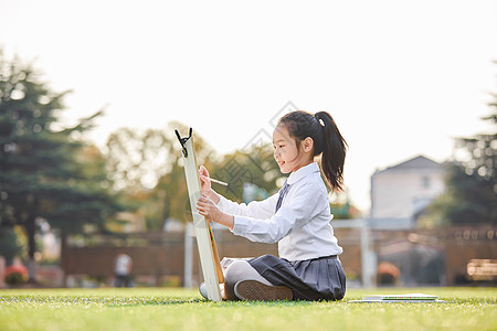 画画的小女孩小学生操场上画画背景