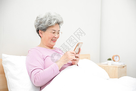 老人床上玩手机图片