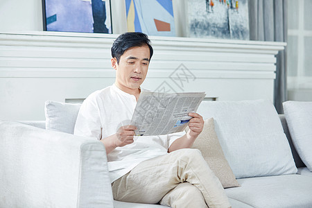 欧式沙发中年男性在家看报纸背景