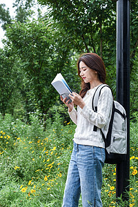 放学路边看书的女学生背景图片