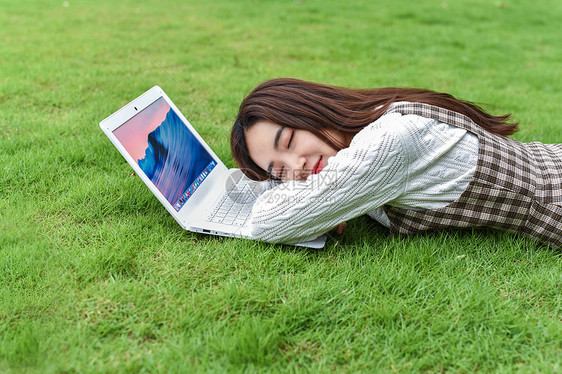 草坪上玩电脑的女生图片
