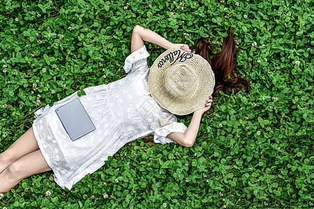 躺在草地戴帽子的女孩图片