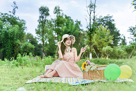 坐着野餐玩耍的美女图片