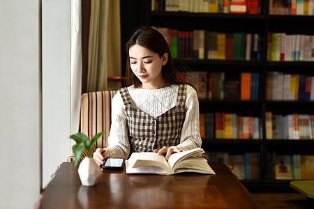 书店坐着阅读的女学生背景图片