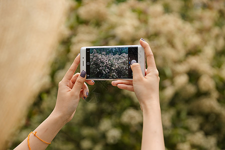 女性郊游拍照手机特写图片
