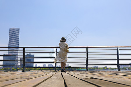 一个在江边观赏风景的女人背影图片