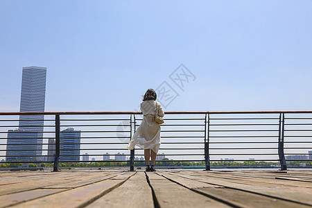 一个在江边观赏风景的女人背影背景图片