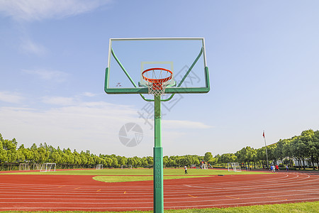 学校操场为背景的篮球场上的篮球架图片