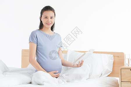 孕妇坐床上看书图片