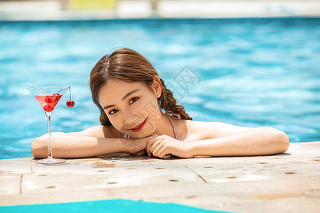 女性游泳池玩水女性游泳池和鸡尾酒背景