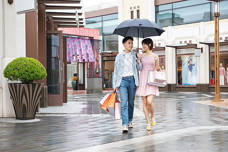 撑伞情侣情侣下雨逛街购物背景