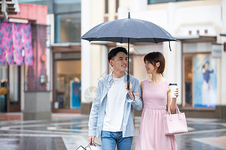 撑伞情侣情侣下雨逛街购物背景