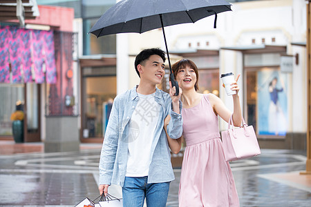 情侣撑伞情侣下雨逛街购物背景