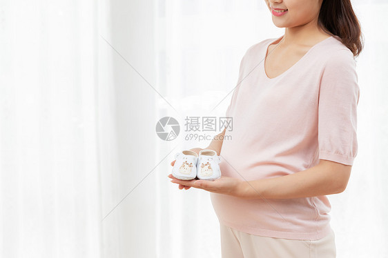 孕妇拿着小孩的鞋子图片