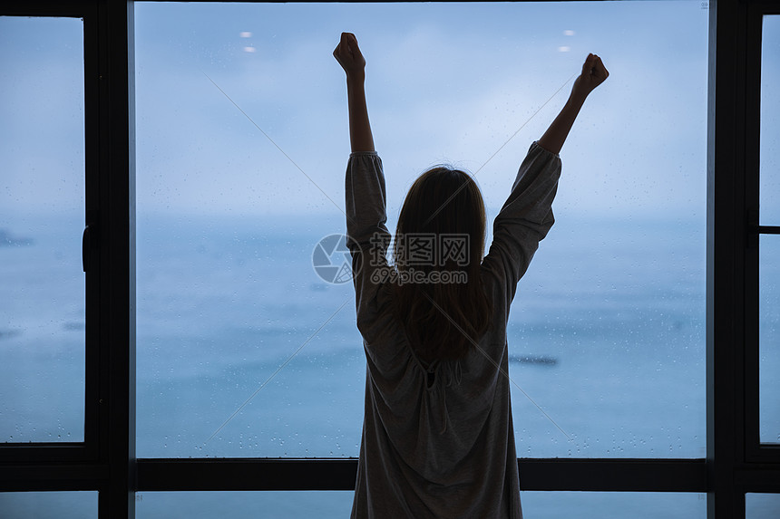 海边雨天年轻女性起床图片