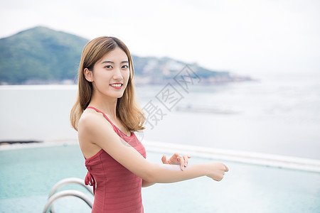 涂防晒霜的美女海边泳池美女涂防晒霜背景