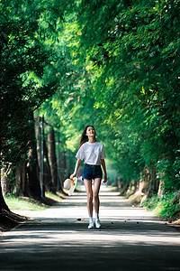 女孩走在林荫小道上图片