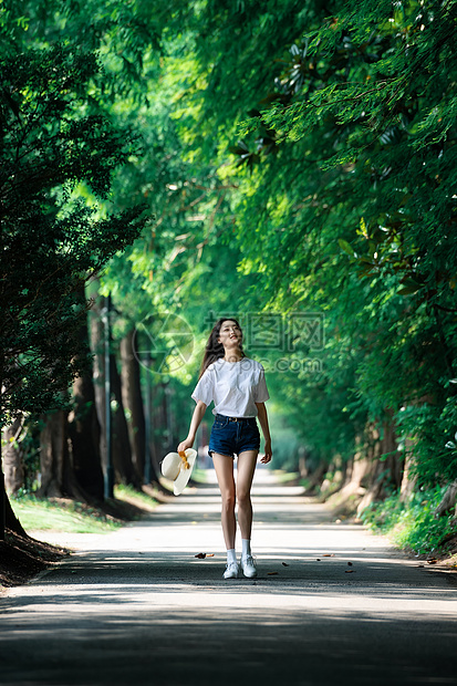 女孩走在林荫小道上图片