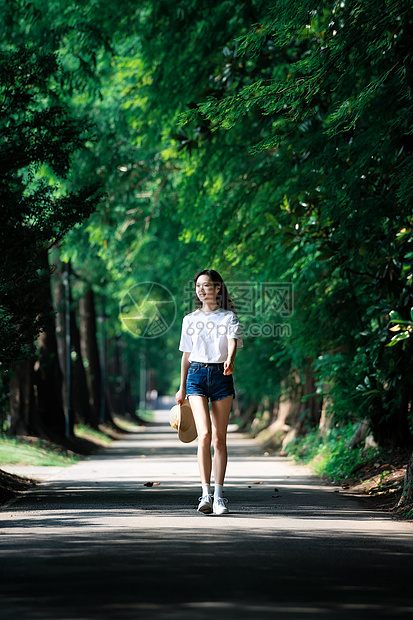 女孩走在林荫小道上图片