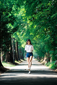 女孩走在林荫小道上图片