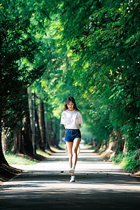 女孩走在林荫小道上图片