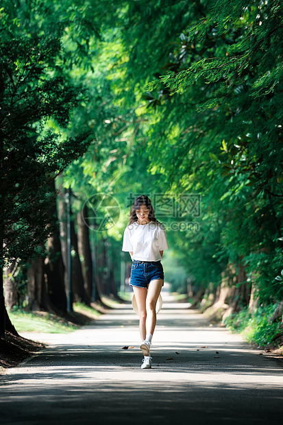 女孩走在林荫小道上图片