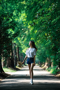 女孩走在林荫小道上图片