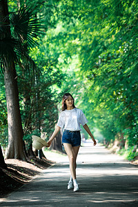 女孩走在林荫小道上图片